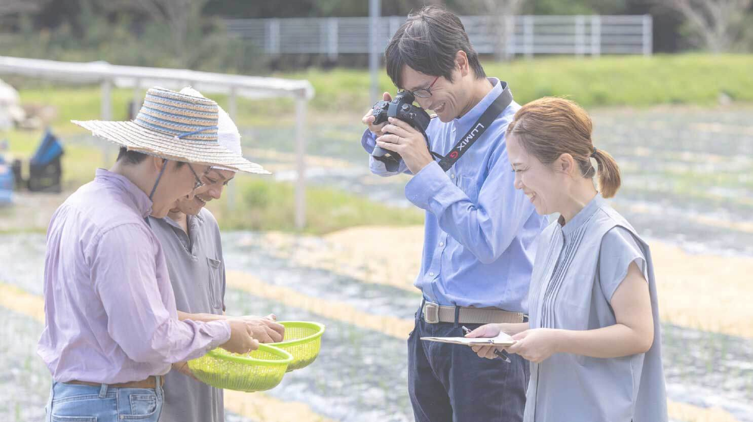 カンパチ漁師の西山慶さんとカメラを撮っているパンクチュアルの男性社員