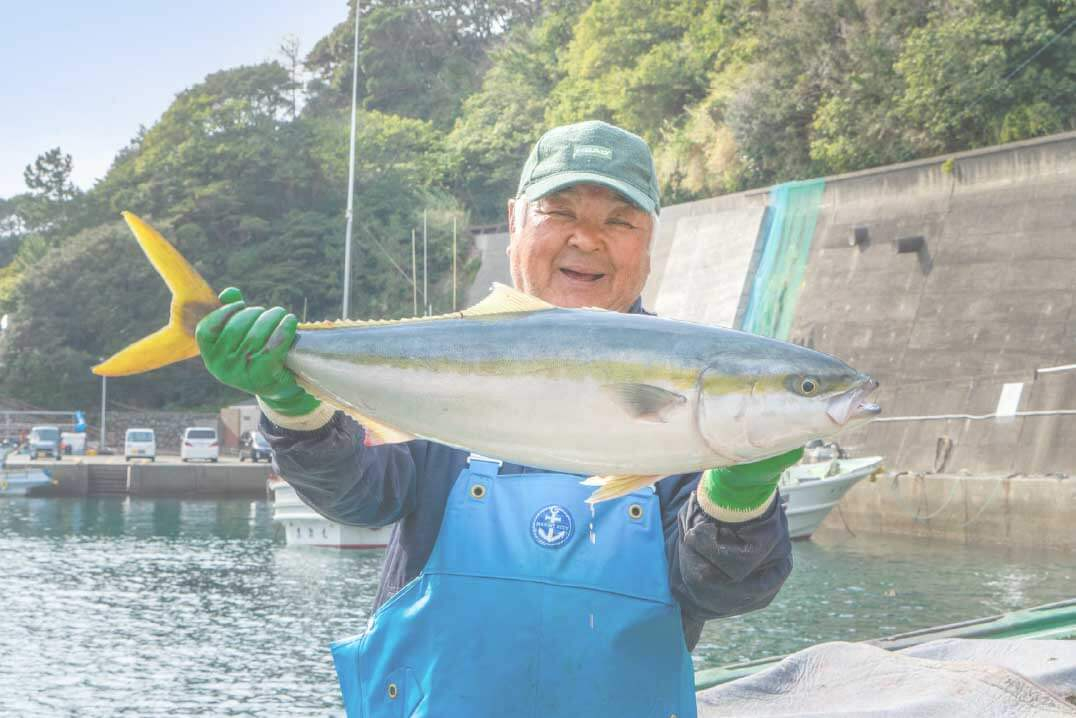 釣った魚を笑顔で見せている男性