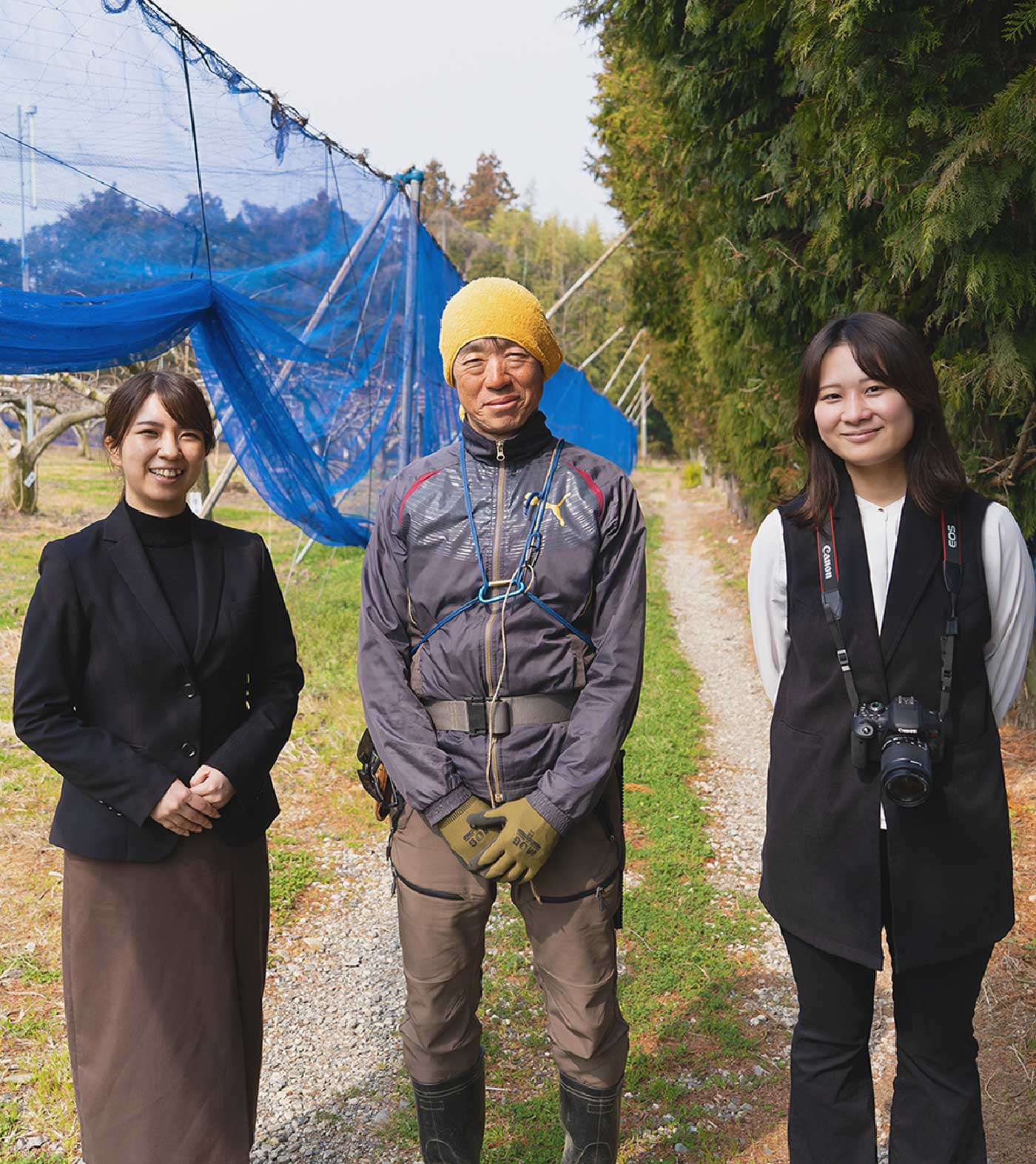 農園でパンクチュアルの社員とこの地域で戦う事業者さんが笑っている写真