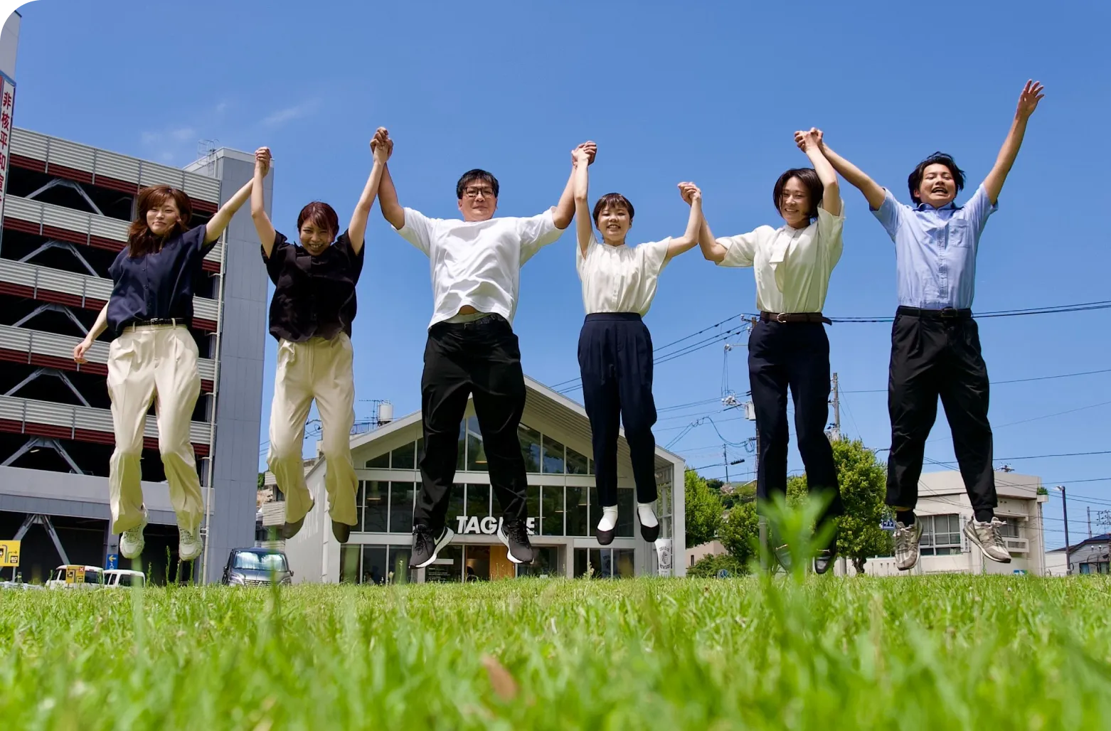 手を繋いでジャンプしているスタッフ
