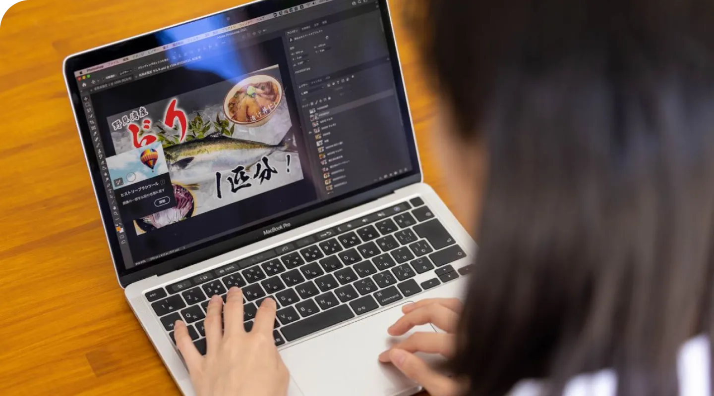 ノートパソコンでECサイトを眺めている女性の後ろ姿