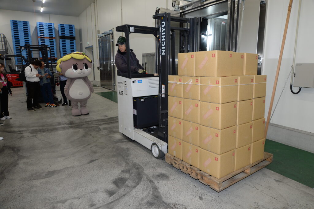 フォークリフトで輸送されるダンボール箱入りのポンカン果汁