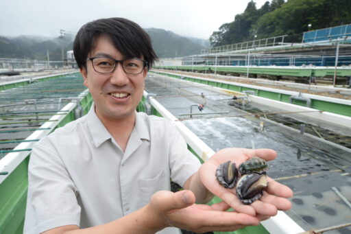 アワビを手にする水産会社専務