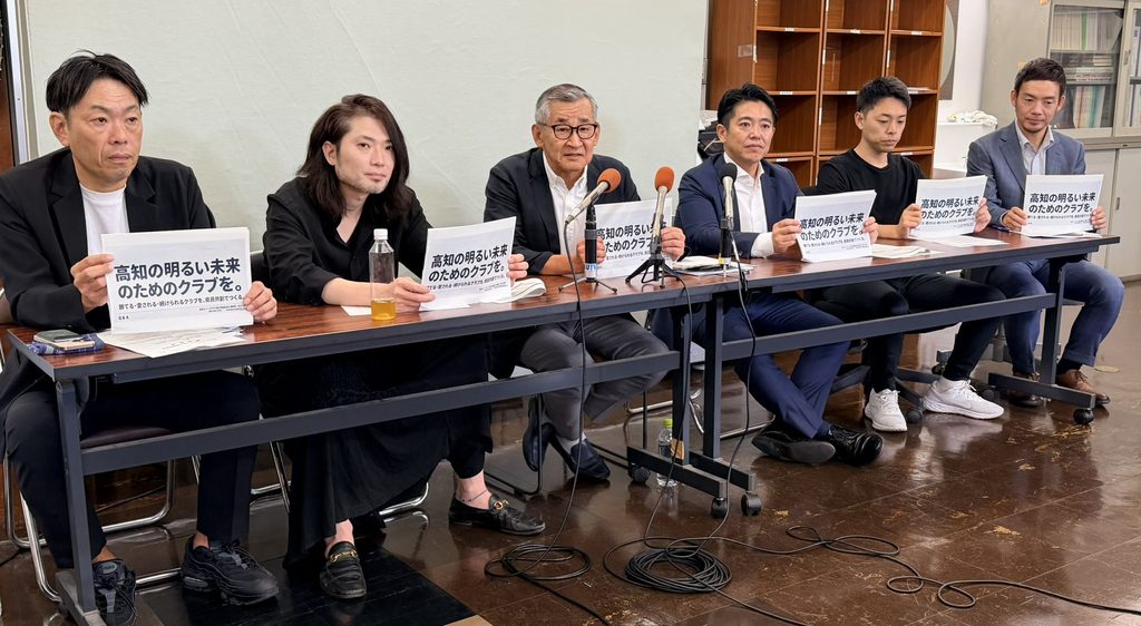 記者会見に臨む関係者